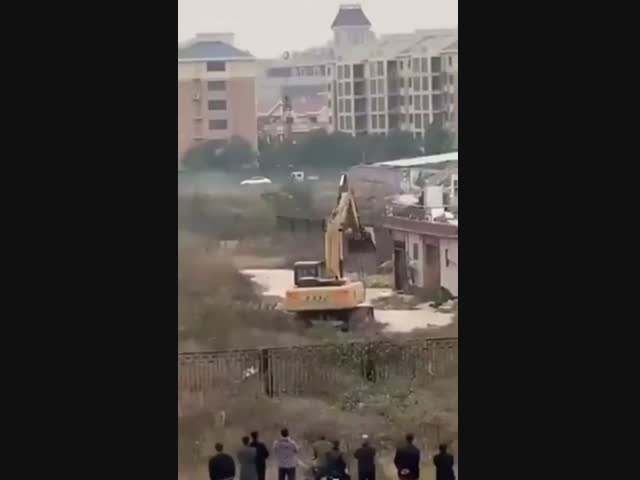 В Китае мужчина с помощью фейерверков отбился от экскаватора, посланного снести его здание